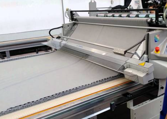 Automatic fabric spreading machine controlling tension before garment cutting