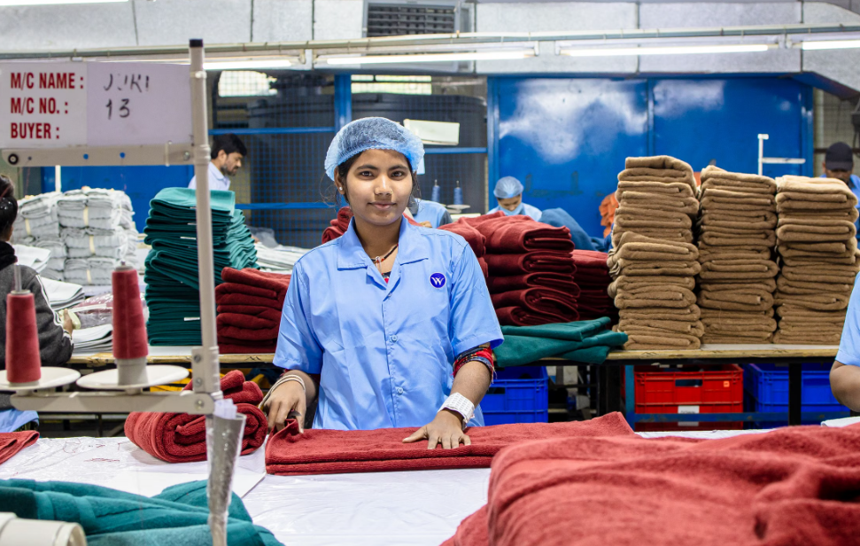 Garment worker checking finished apparel during factory finishing and packing